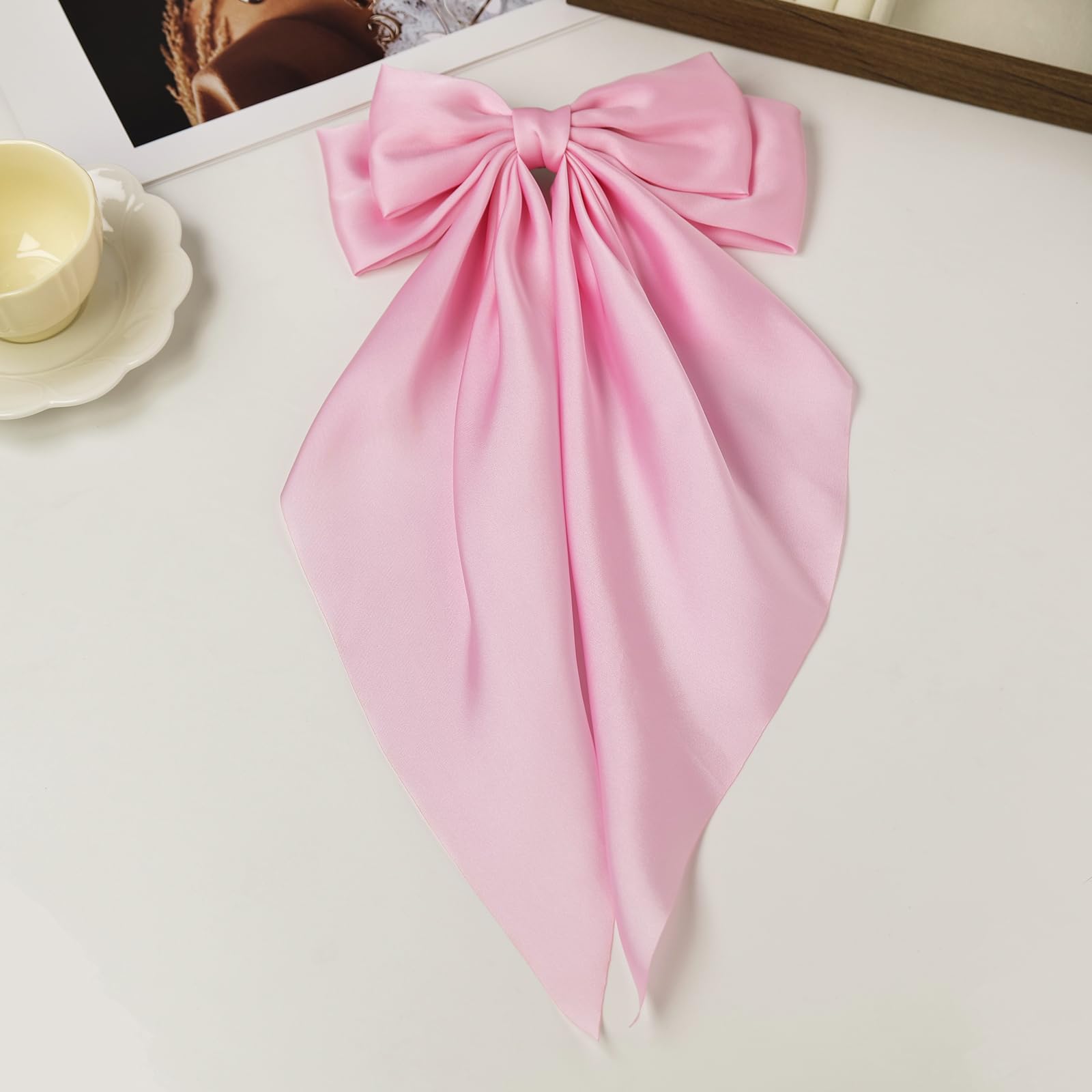 JGQUR bow size comparison on hand illustrates scale and wearable comfort