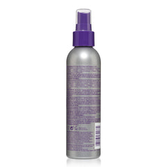 jhirmack bottle next to hairbrush showing travel-friendly size and convenience