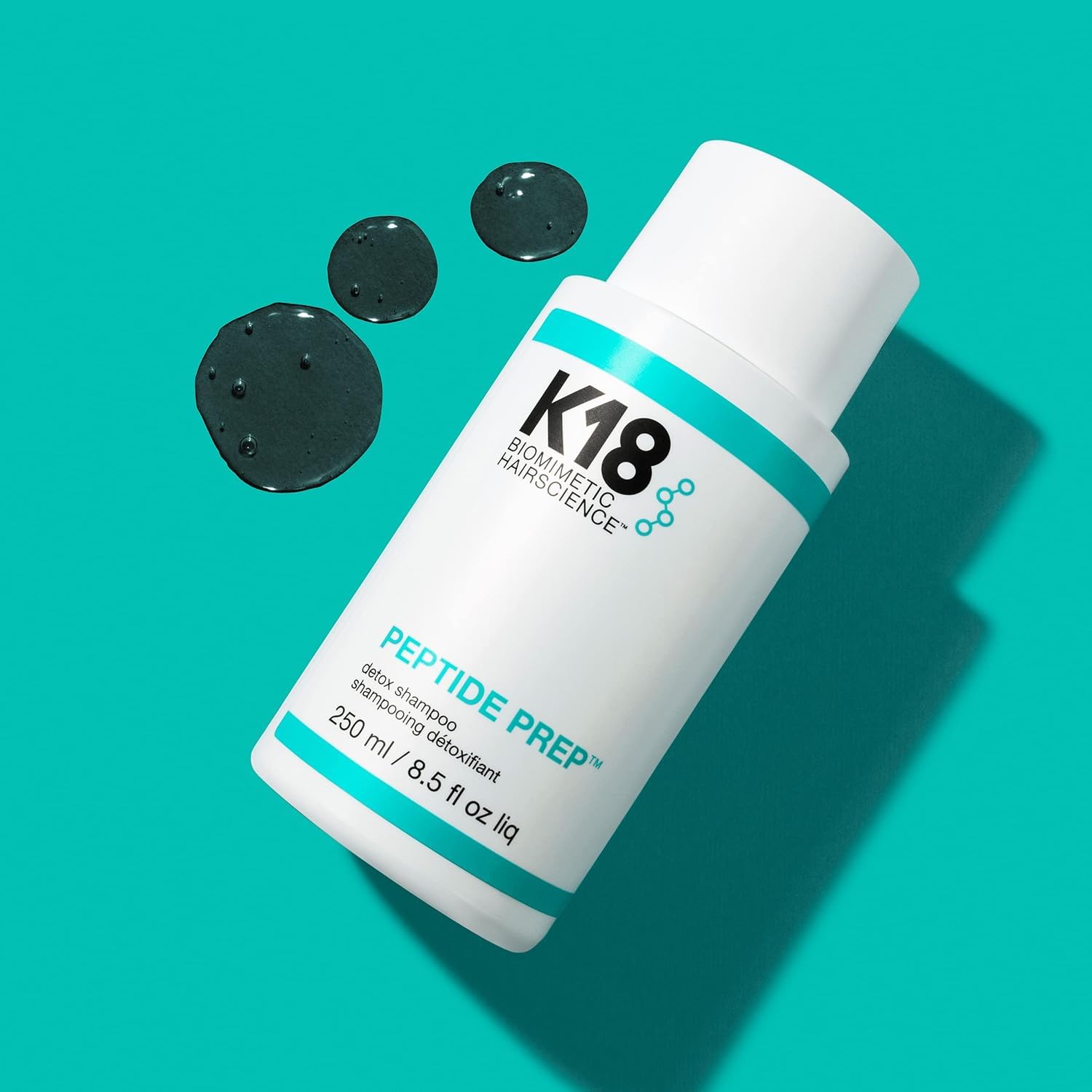 K18 16 fl oz bottle held in hand to show actual product size