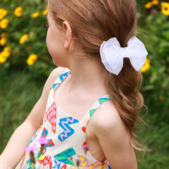 KCHIES bow next to ruler showing 4-inch size for proper fit reference