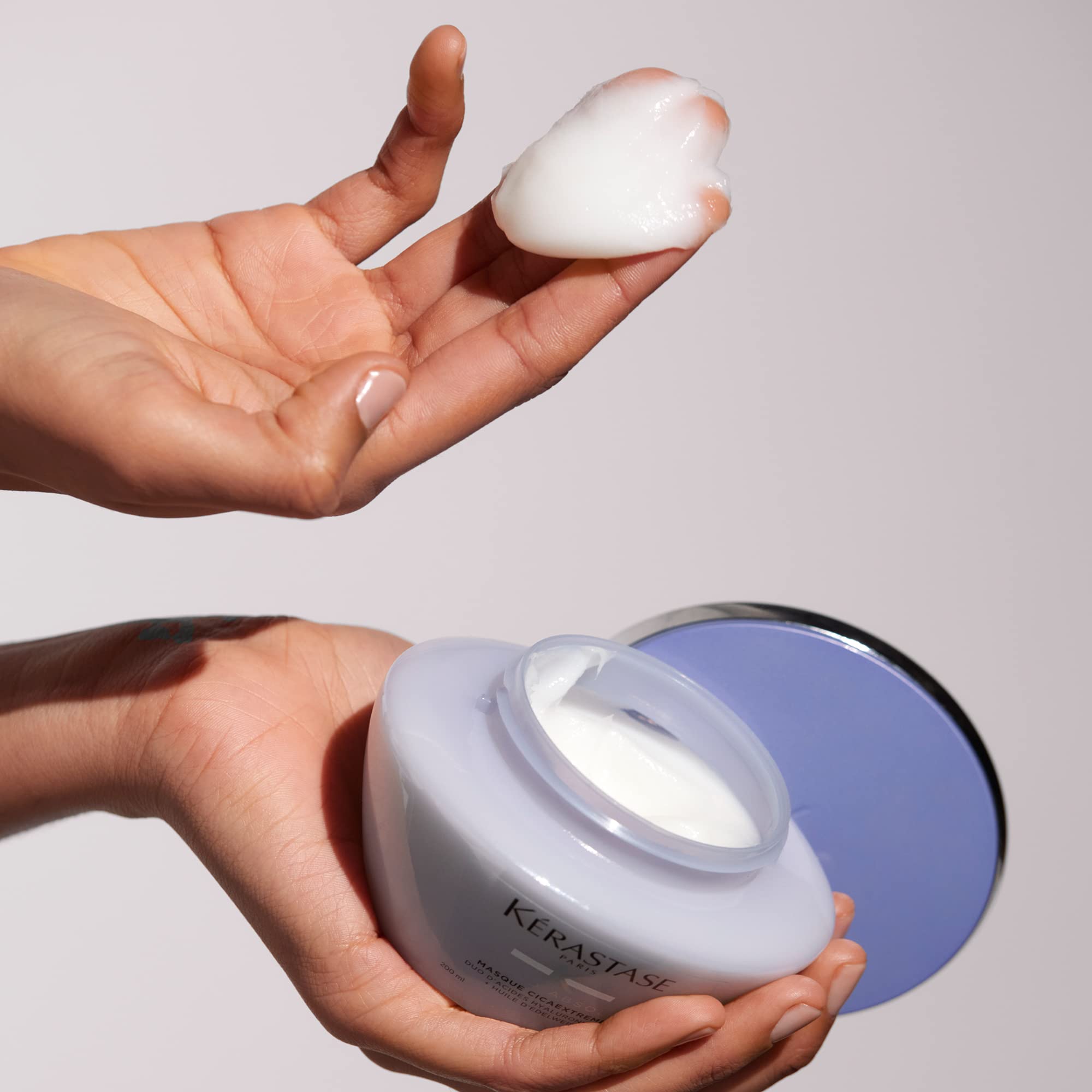 KÉRASTASE jar held in hand showing product size and practical travel benefit