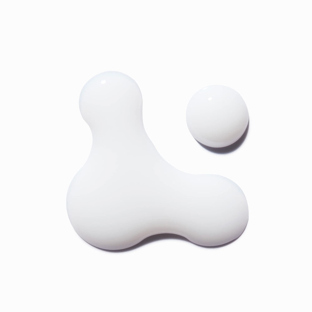 KÉRASTASE bottle in hand for size scale, conveys travel-friendly 5.1 fl oz convenience