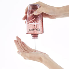 KÉRASTASE bottle in hand for scale showing portable 8.5 fl oz benefit