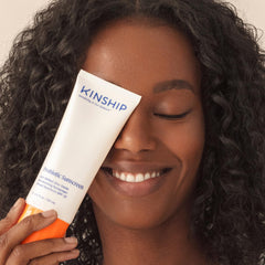 Kinship 1.75 oz tube next to coin showing compact travel-friendly size