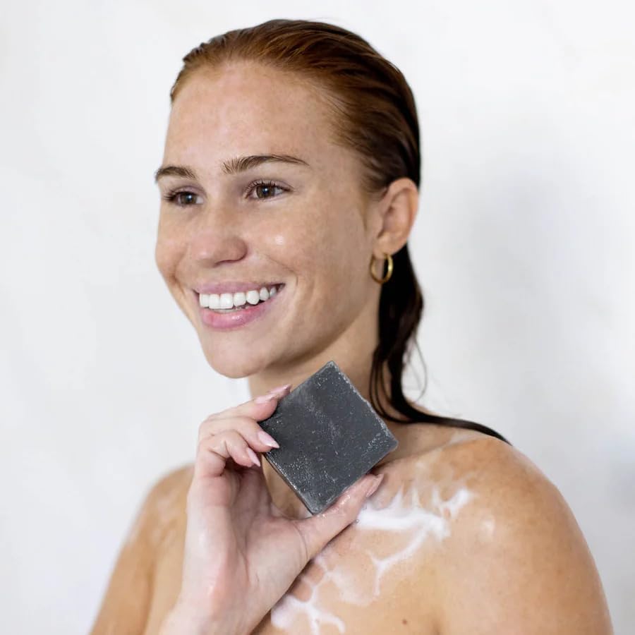 Kitsch charcoal soap travel ready beside toiletry bag indicating compactness and convenience benefit