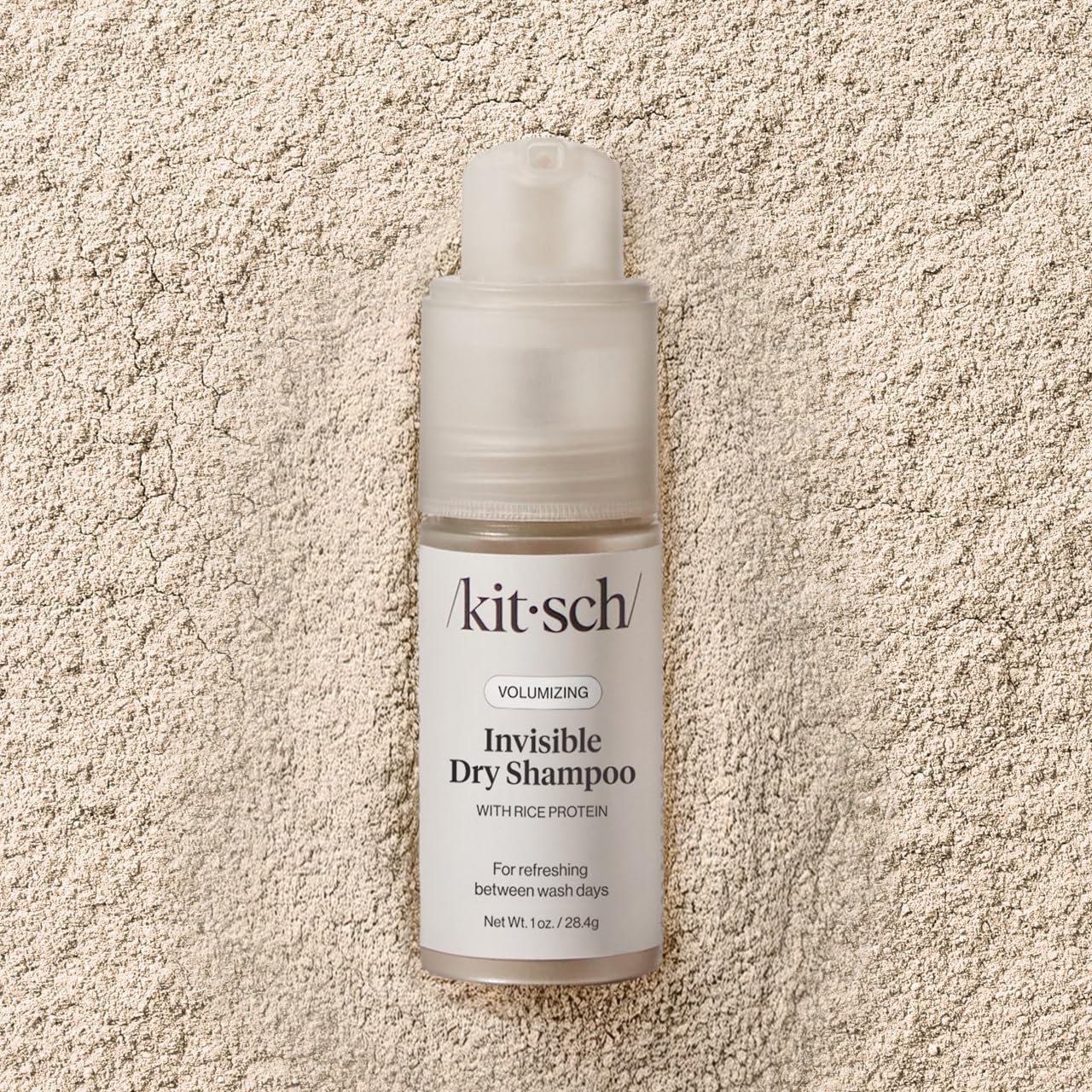 Kitsch 1oz bottle beside a coin showing compact travel-friendly size