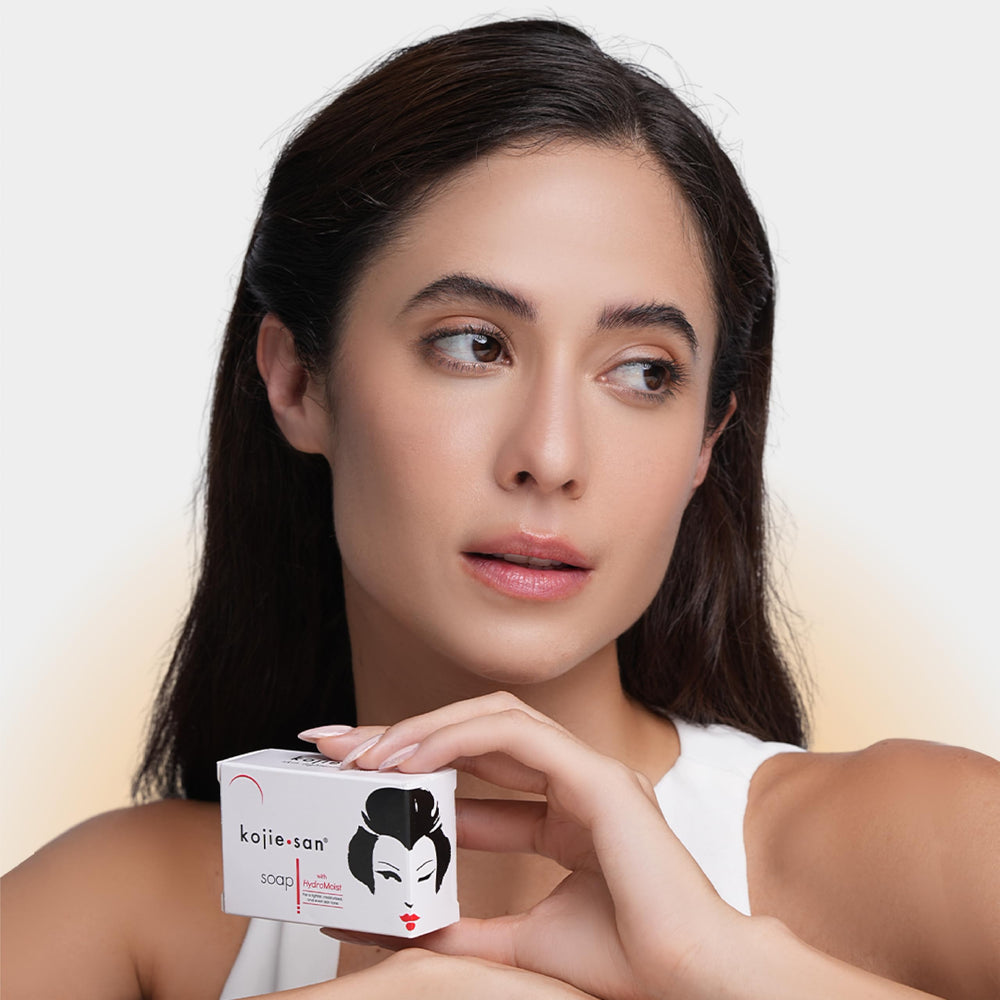 Kojie San applied on face in mirror, illustrating targeted spot care benefit