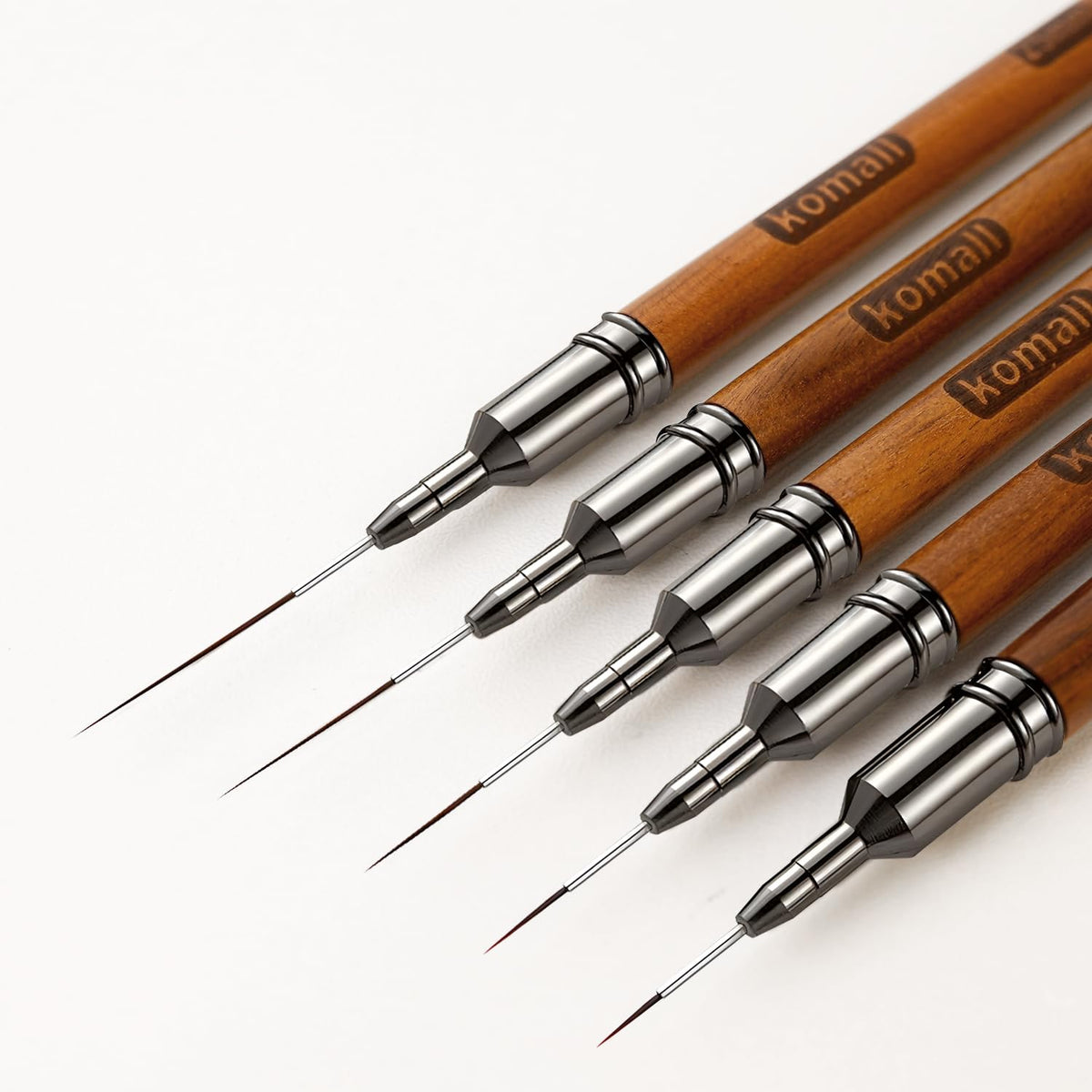Komall front view brush set showing five wooden-handled liner brushes for versatility