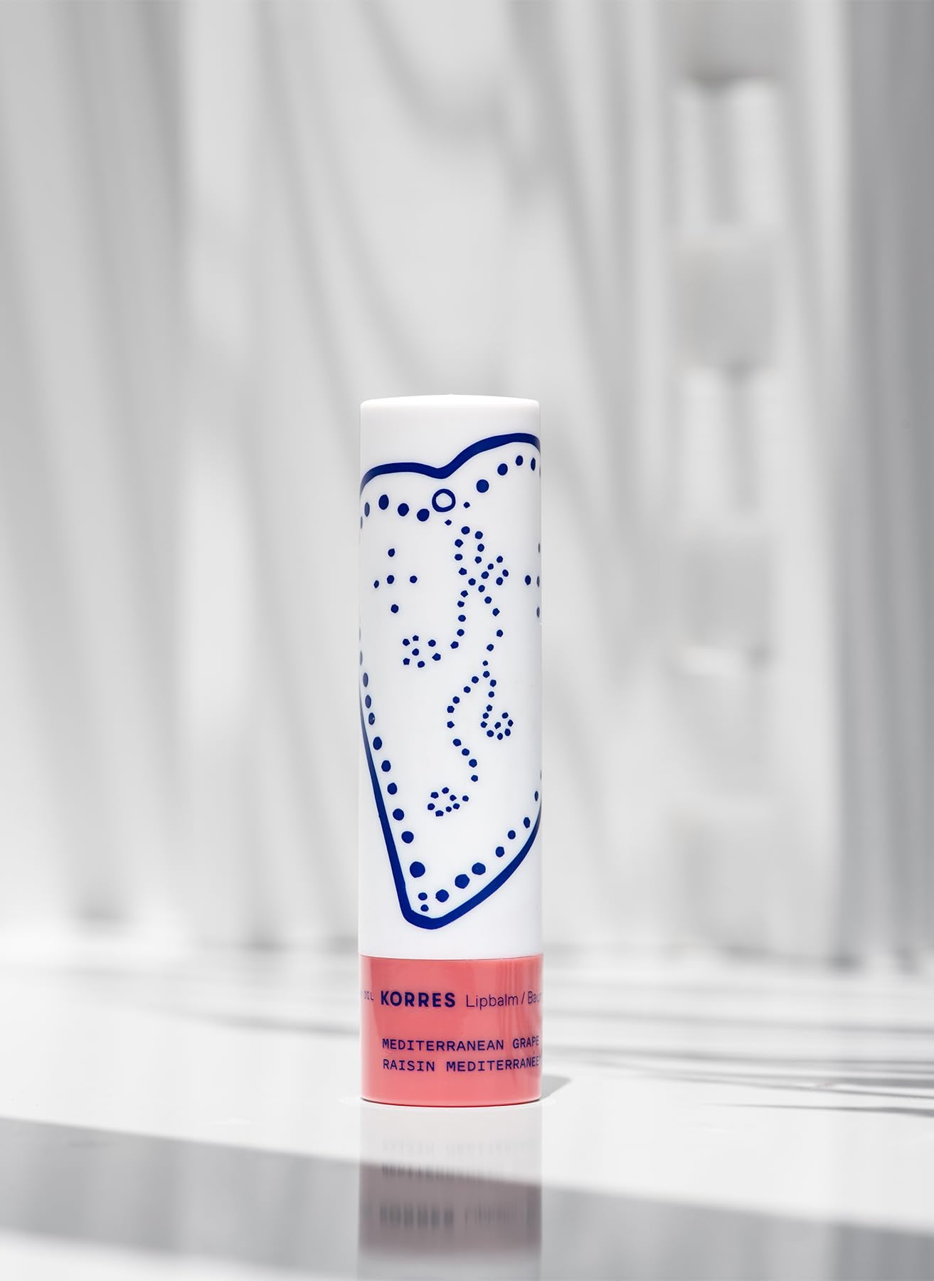 KORRES Lip Butter Stick applied on lips in lifestyle scene for easy touch-ups
