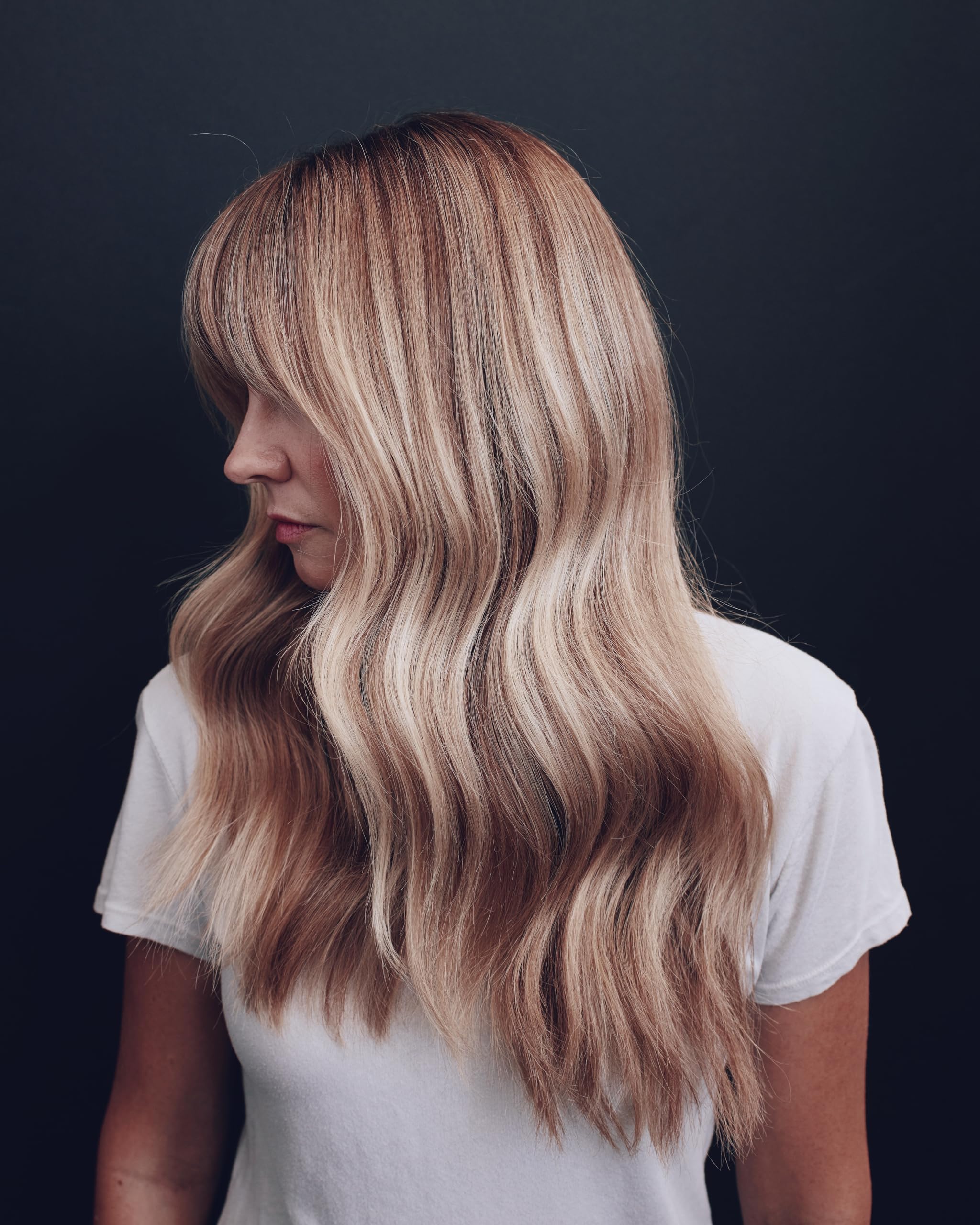 Kristin Ess conditioner being applied in shower, tones and hydrates hair