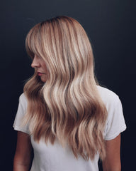 Kristin Ess conditioner being applied in shower, tones and hydrates hair
