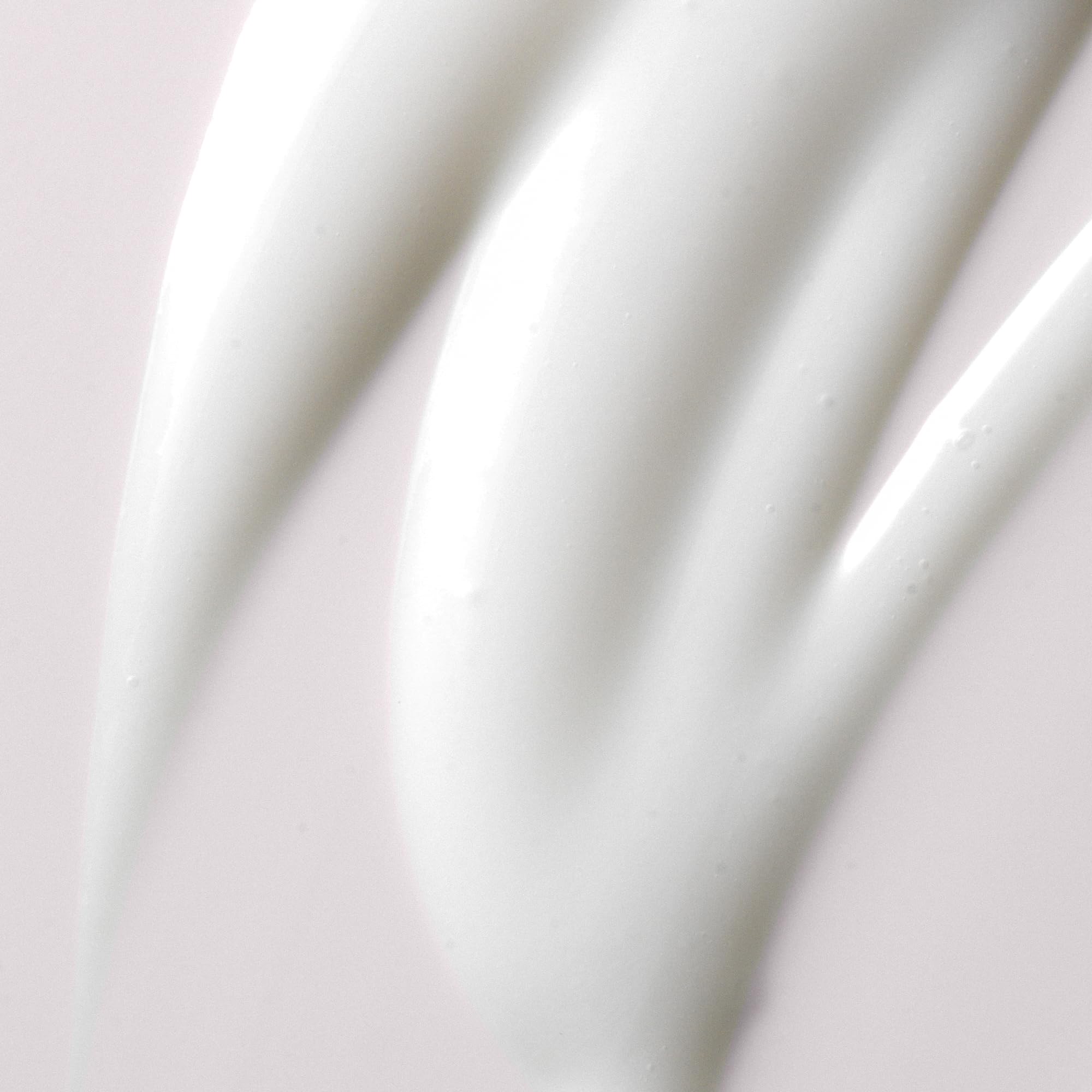 Kristin Ess cream texture on fingers illustrating smooth slip and hydration