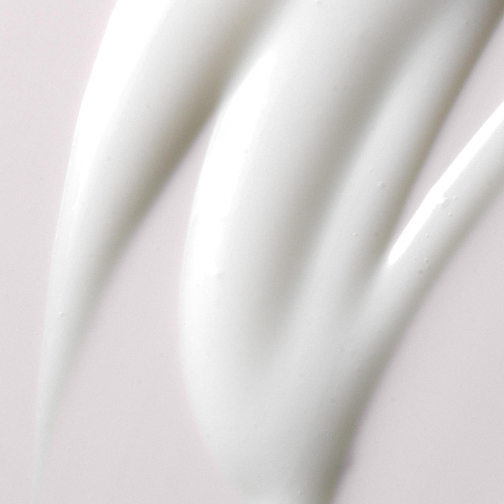 Kristin Ess cream texture on fingers illustrating smooth slip and hydration