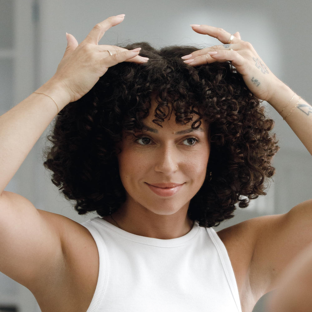 Kristin Ess applied to scalp by model demonstrating targeted moisturization