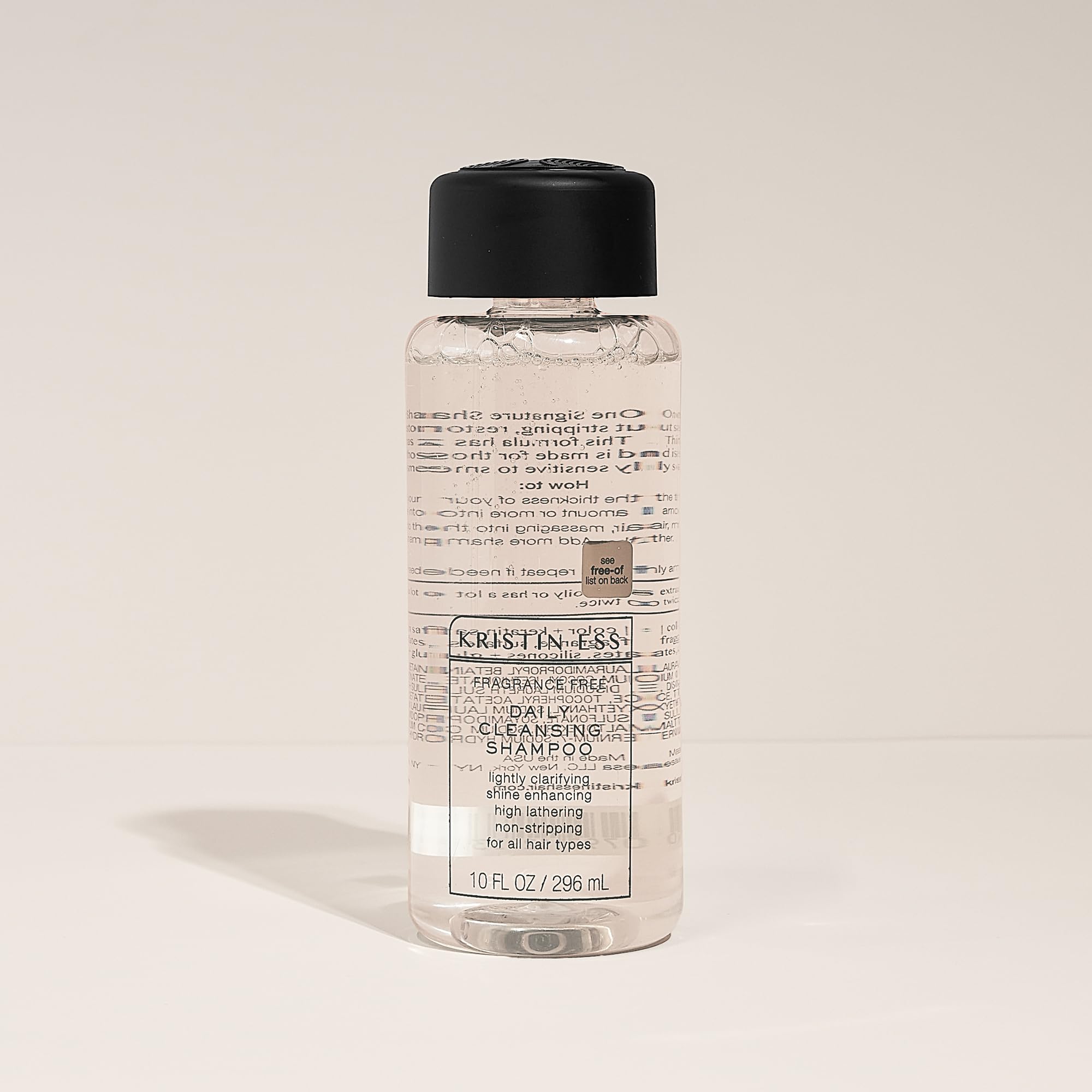 Kristin Ess bottle beside a ruler showing 10 fl oz size