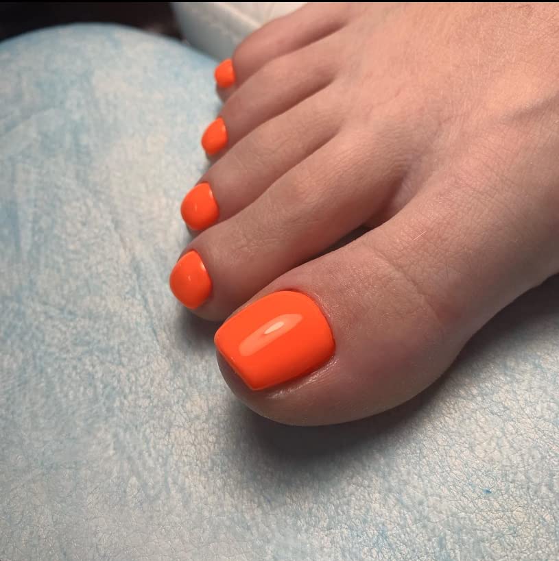 KXAMELIE glossy orange toenail close-up showing smooth finish and salon shine