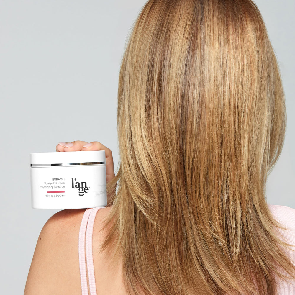 L'ANGE HAIR 10 oz tub next to hand to show size and travel convenience