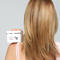 L'ANGE HAIR 10 oz tub next to hand to show size and travel convenience