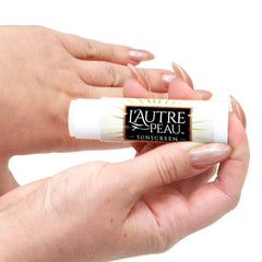 L'AUTRE PEAU sticks next to travel items illustrating TSA-friendly portability