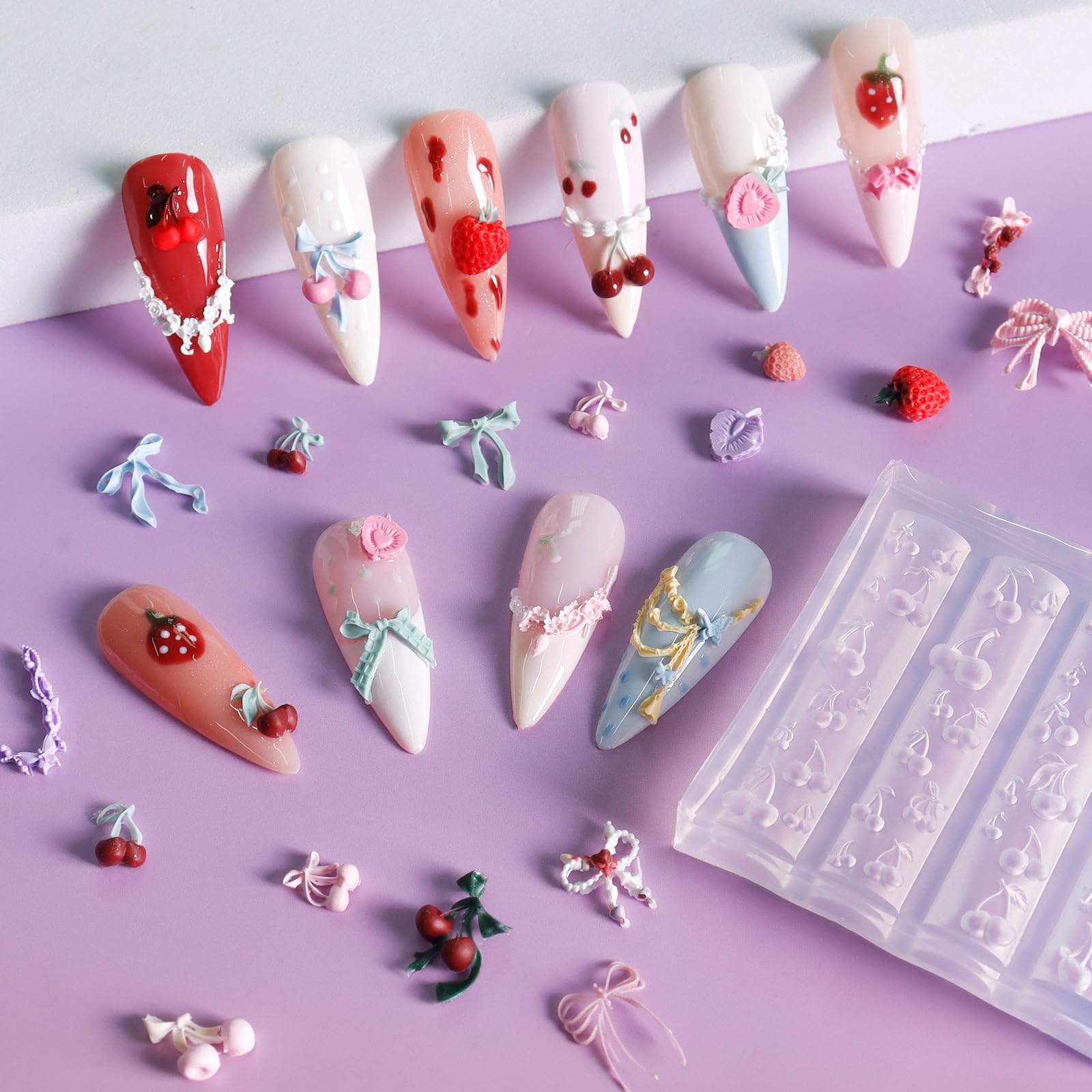 Laza demolded small strawberry and bowknot charms on white background, ready to apply