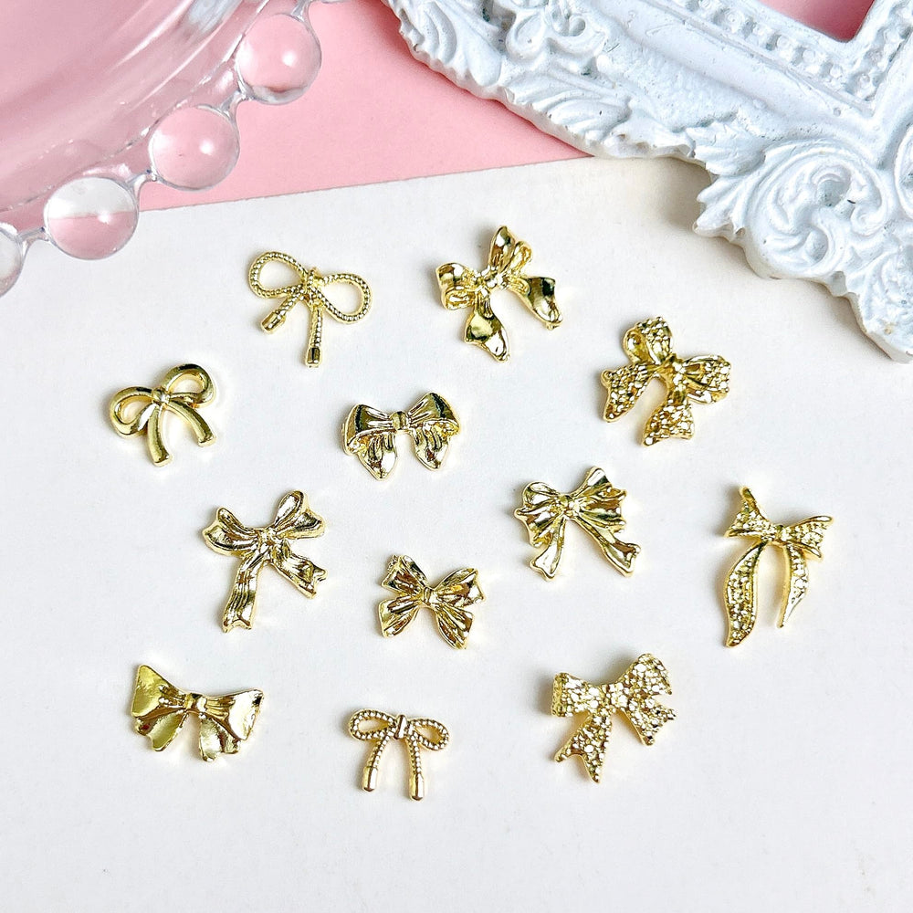 LERBOU gold bow charms applied on acrylic nails demonstrating glam finish