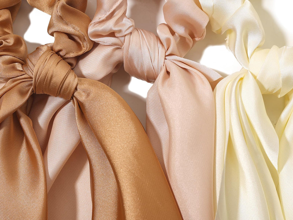 LFOUVRE scrunchie beside a coin for size comparison showing compact, travel-friendly design