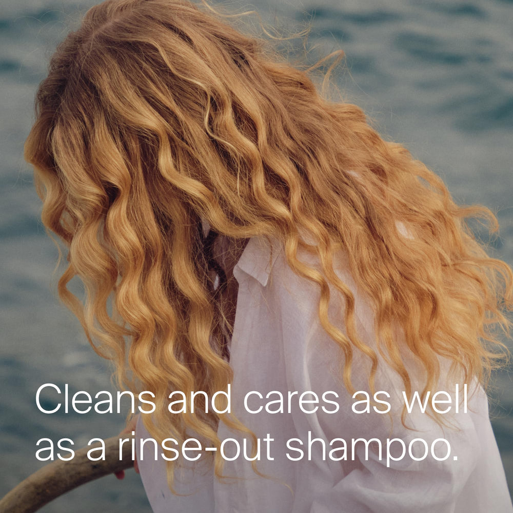 Living Proof spritzing on roots to remove oil and refresh hair benefit
