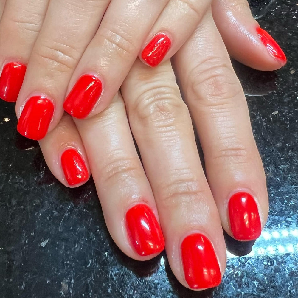 Love easy finished red manicure in lifestyle shot highlighting glossy results