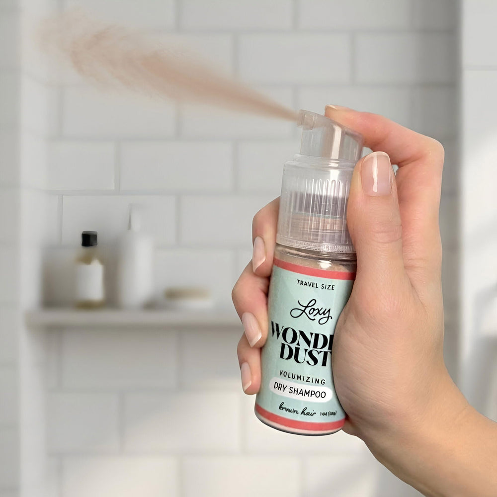 Loxy in use applying powder to roots to instantly absorb oil and add lift