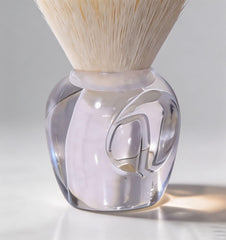 Lumcrissy brush next to fingers showing scale and travel-friendly portability