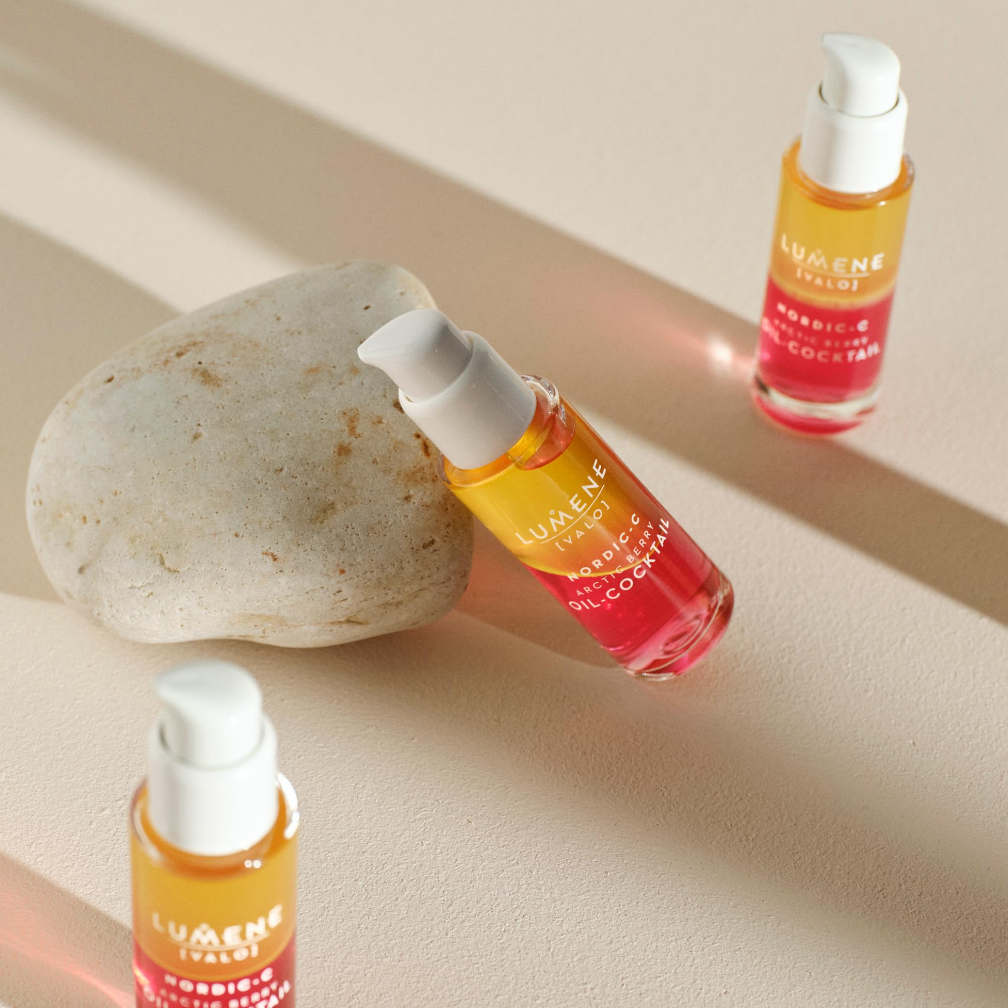 Hand holding Lumene 30 ml bottle to illustrate compact travel-friendly size