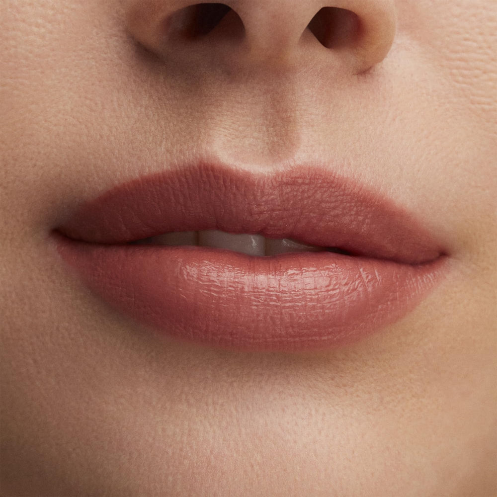 MAC Lustre Hug Me swatch on arm illustrating sheer nude-beige payoff