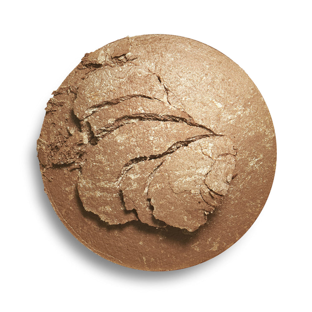 Makeup Revolution bronzer swatch with brush showing buildable shimmer benefit