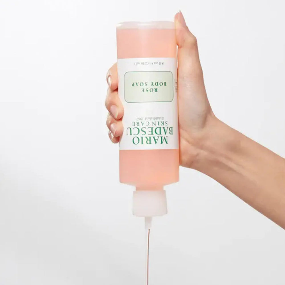 Mario Badescu bottle next to hand for scale to show travel-friendly size