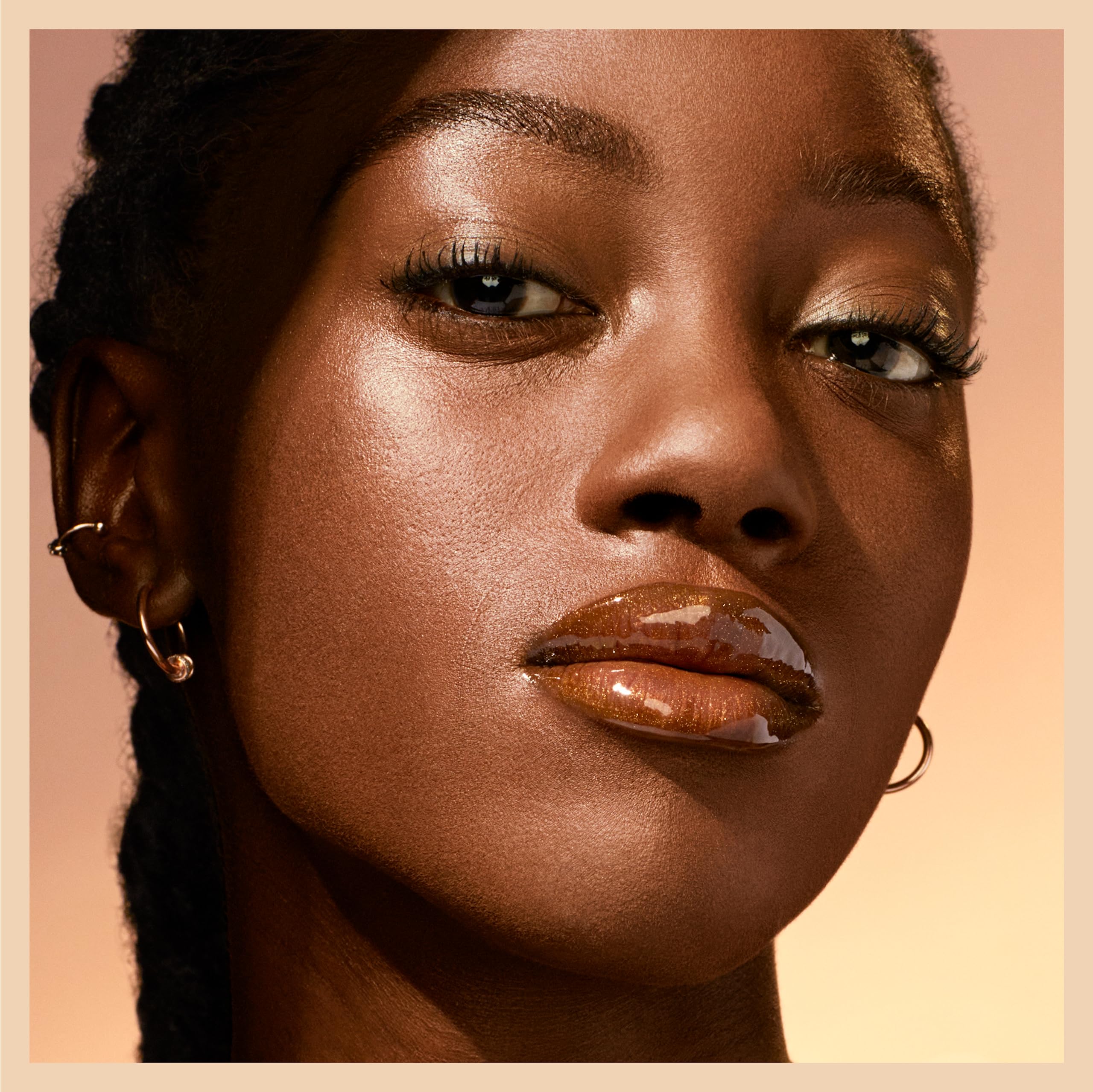 Maybelline Opal gloss staged with other makeup showing versatile topcoat benefit