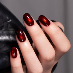 MEGIOR manicure on hand showing finished cherry bomb cat-eye nails for impact