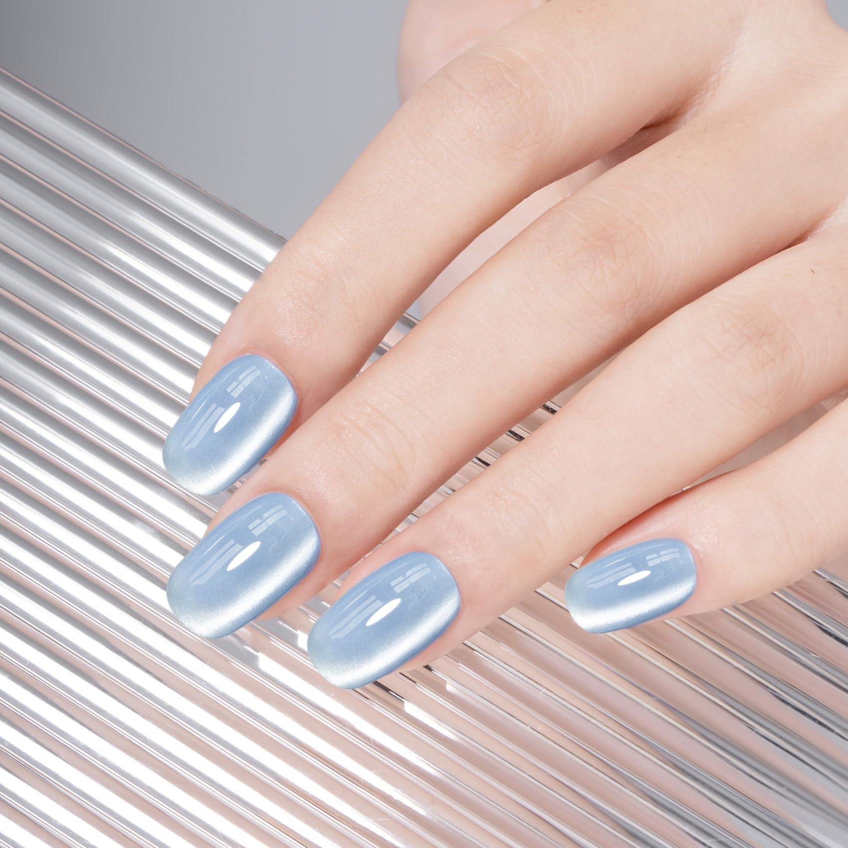 MEGIOR nail swatch on fingers displaying shifting blue holographic finish