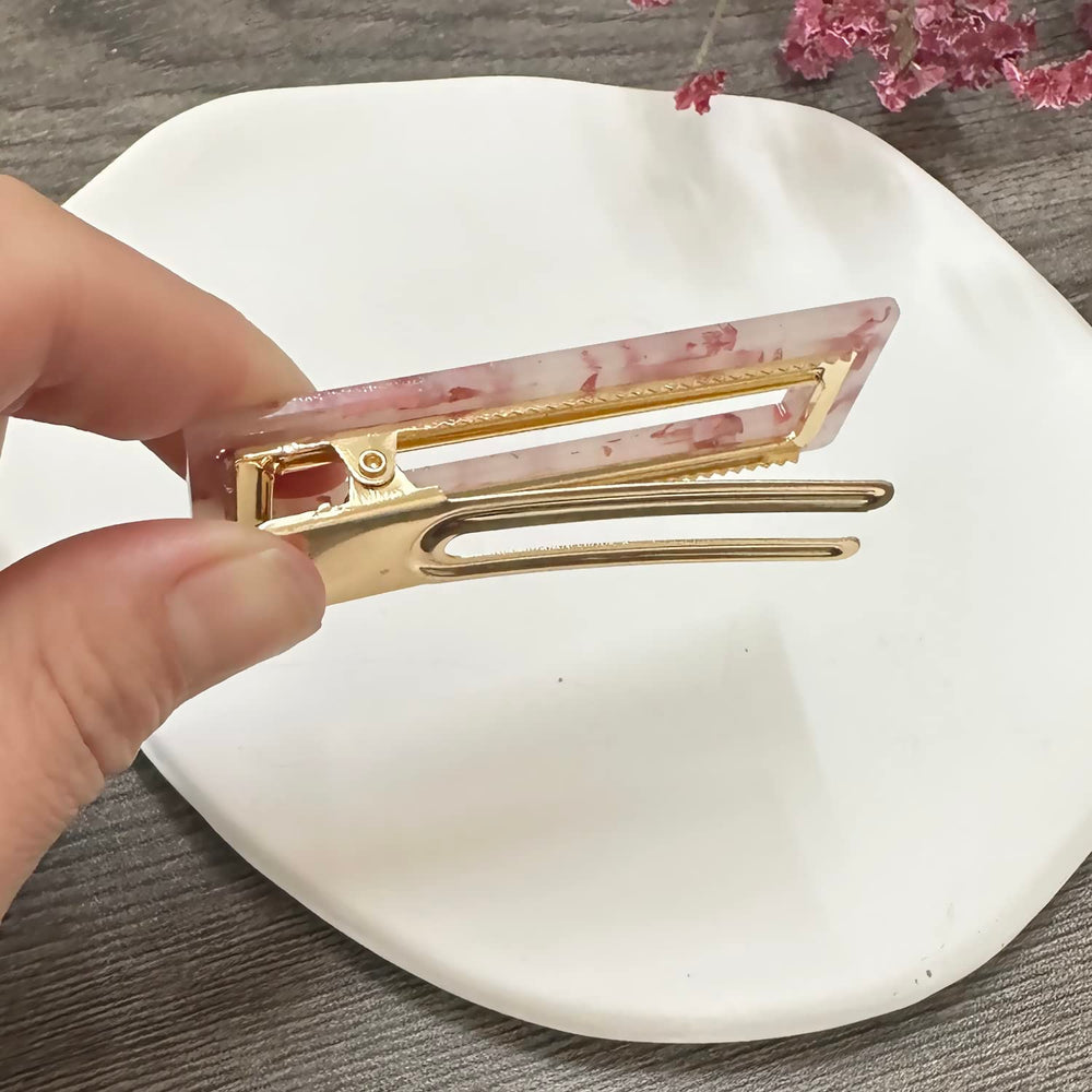 Mehayi clips held in hand for scale showing size and portability benefit travel convenience