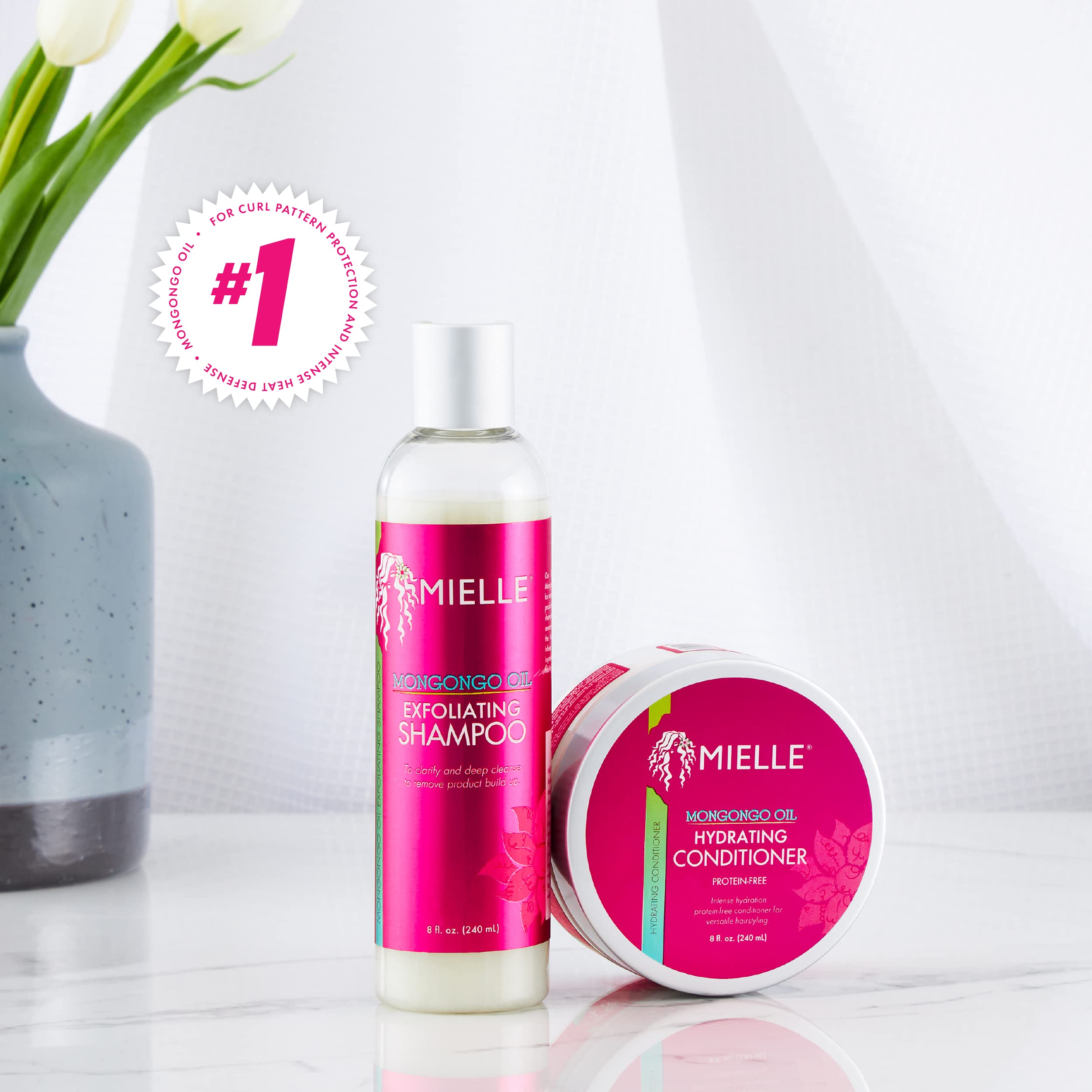 Mielle Organics bottle beside mongongo nuts and oil showing nourishing ingredient