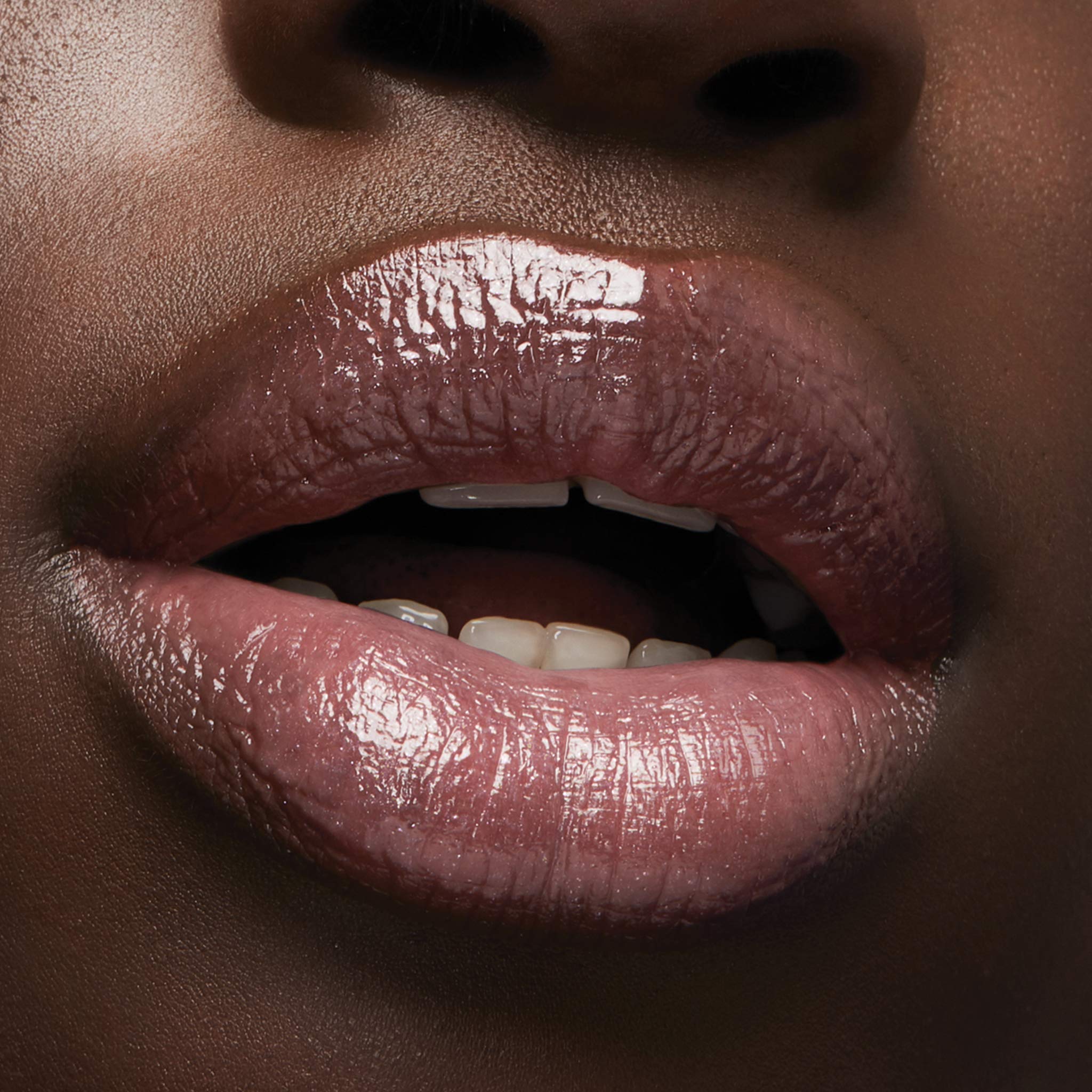 Milani Luminoso swatch on lips showing warm pink brightening the smile