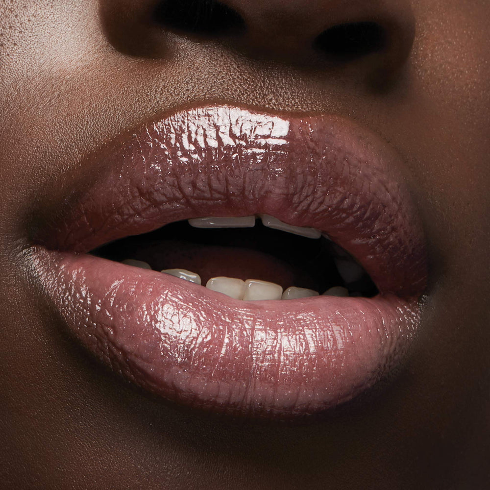 Milani Luminoso swatch on lips showing warm pink brightening the smile