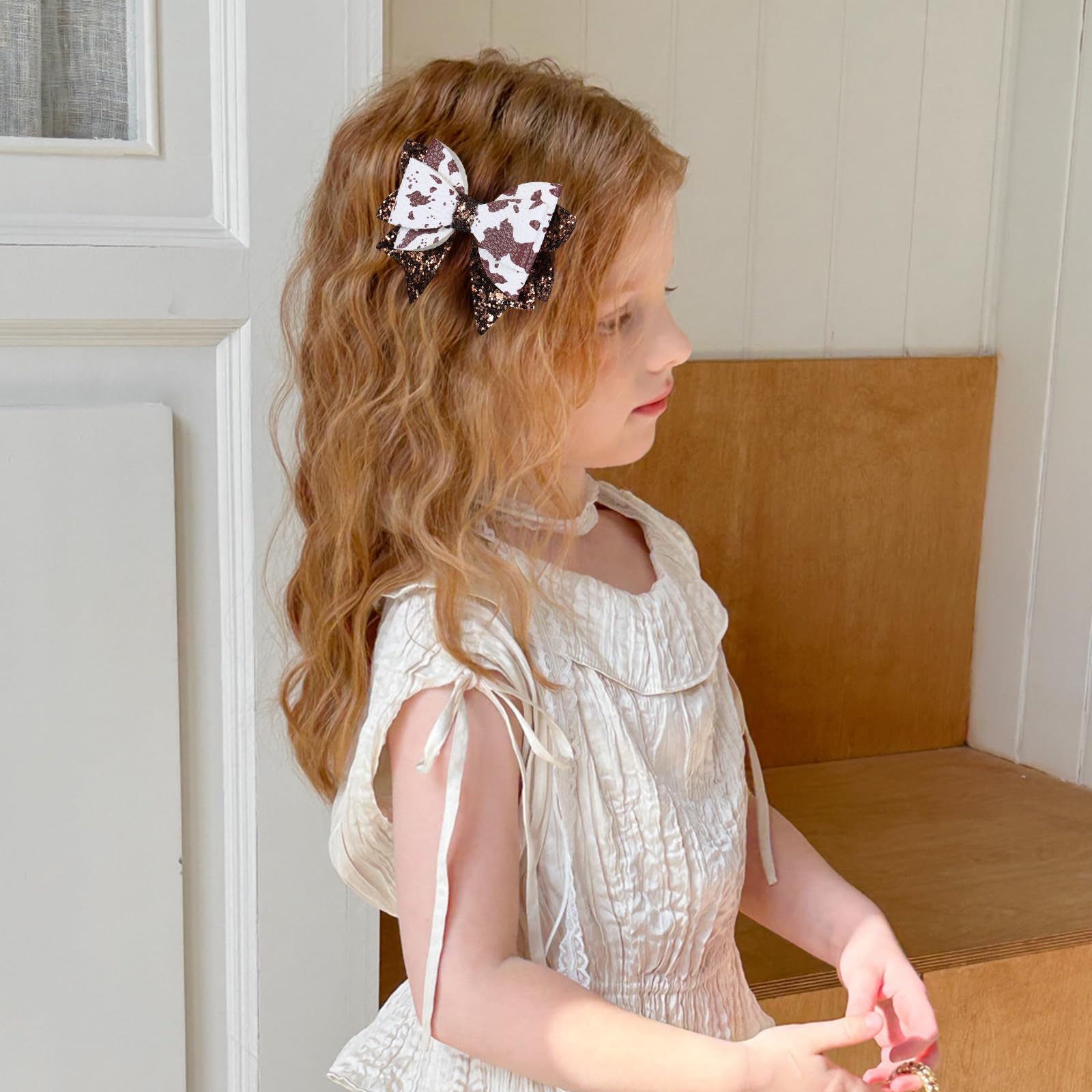 Miroksh bow held in an adult hand to show true 3.5-inch scale for styling decisions