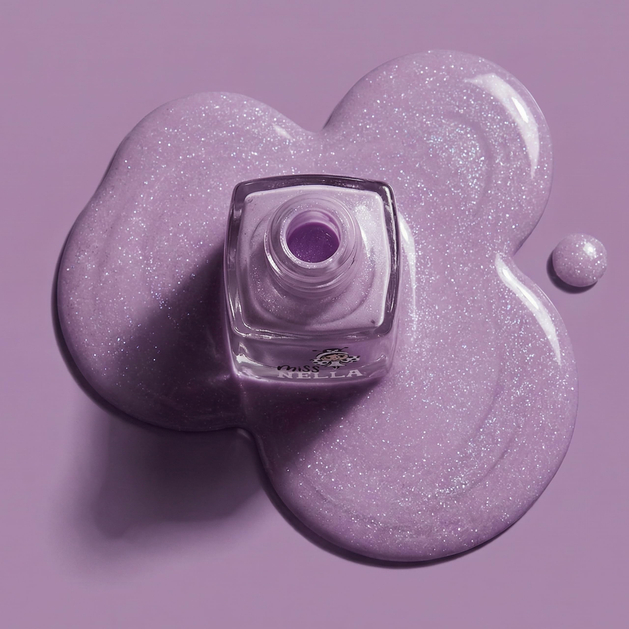 Miss Nella size comparison beside a coin showing compact, travel-friendly bottle
