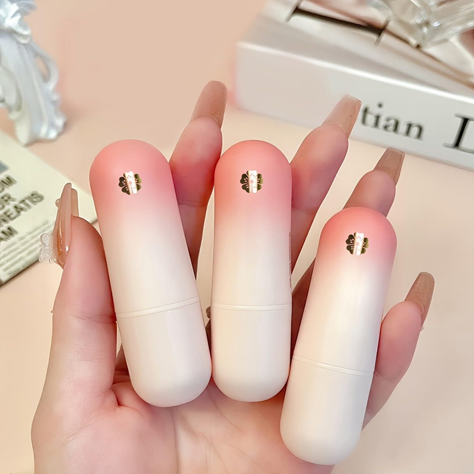 MooGlamor tubes beside a hand to show slim size and travel-friendly convenience