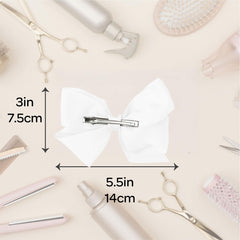 Motique Accessories bow next to hand to show true size and scale