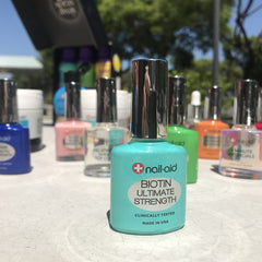 Nail-Aid two-pack staged with travel items showing convenient on-the-go use