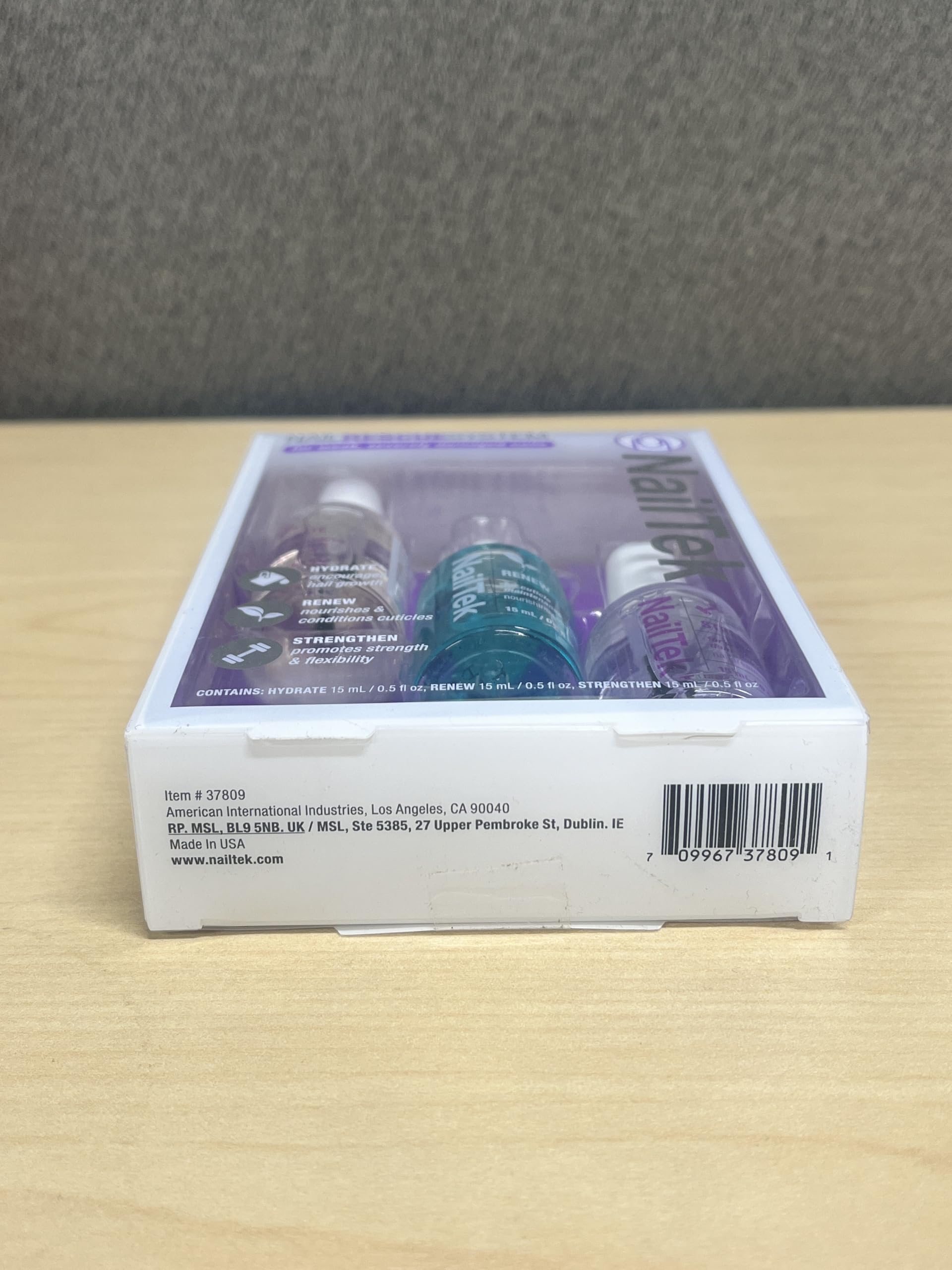 side-by-side with a coin showing Nail Tek 0.5 oz compact travel-friendly size