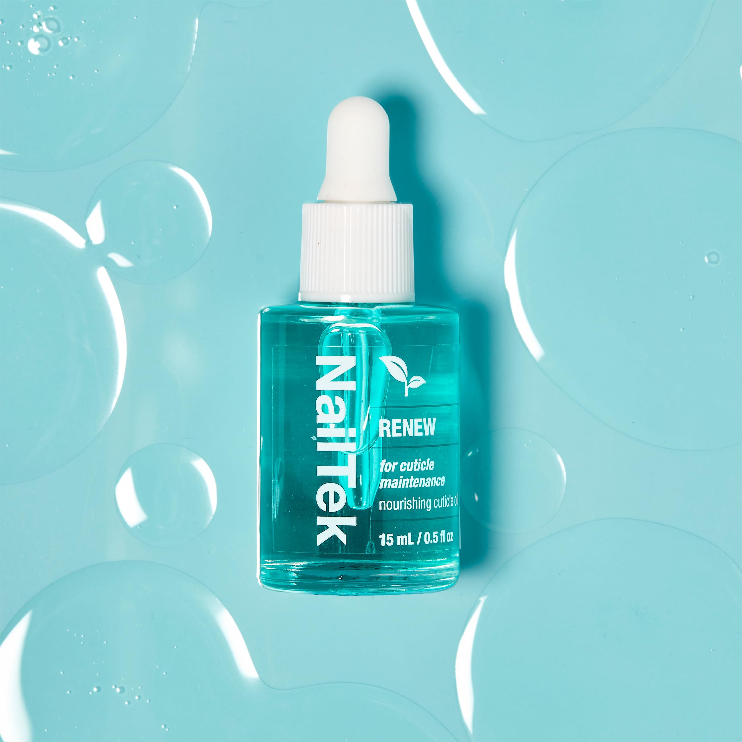 Nail Tek bottle next to a coin illustrating compact 0.5 fl oz size