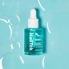 Nail Tek bottle next to a coin illustrating compact 0.5 fl oz size