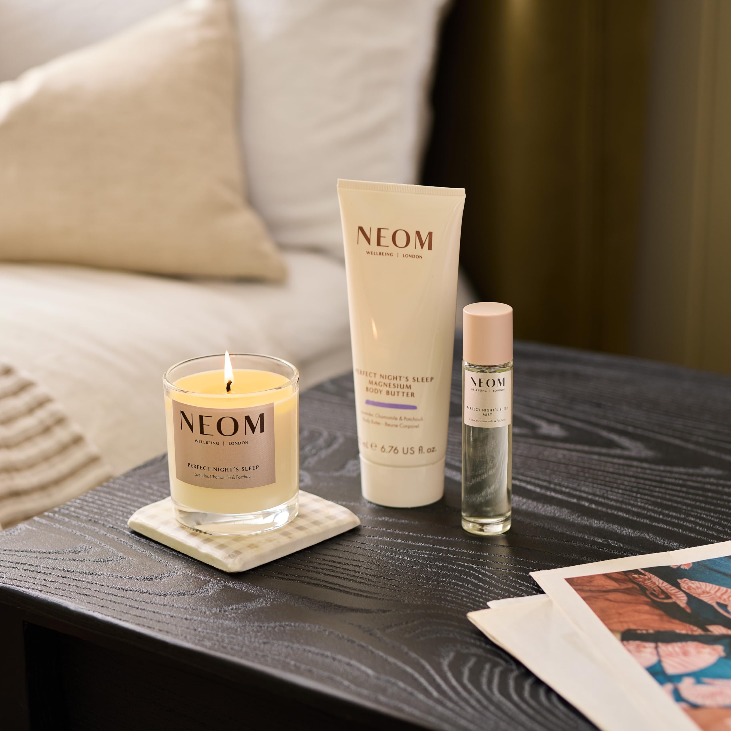 Neom jar next to a book to show 200ml size and gift-ready presentation